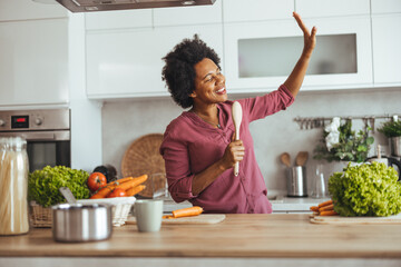 Joyful Woman Singing While Cooking in Modern Kitchen