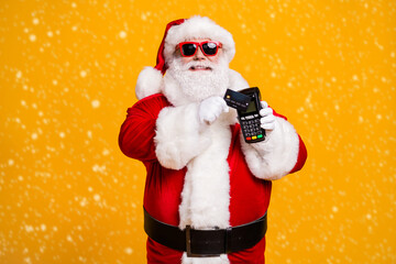 Portrait of his he nice attractive cheerful fat overweight Santa using wireless bank card digital terminal paypass system isolated bright vivid shine vibrant yellow color background