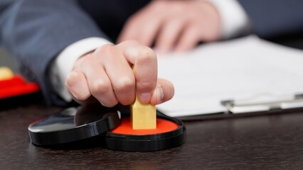 契約書に印鑑を押すビジネスマンの手元