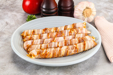 Raw sausages wrapped in bacon