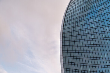 Angled view of modern skyscrapers in business district against blue sky. Looking Up high-rise office buildings.