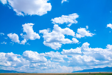 Panoramic view of sky with clouds over green field. Beautiful landscape with fluffy clouds.