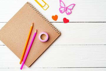 Crafting inspiration with colored pencils, decorative tape, and playful shapes on a rustic wooden surface