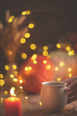 Autumn cozy composition. Tea in a mug, pumpkins and candles