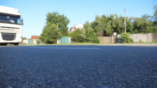 Blurred shot of truck driving along highway in country road. Lorry rides through the rural. Slow motion Bottom iew Close up