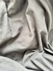 Fototapeta premium Softly draped gray fabric creates a minimalist, textured background, perfect for modern design projects or social media content. Ideal for adding subtle elegance to branding, mockups.