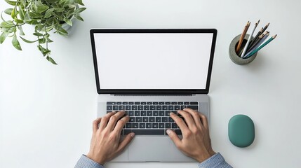 Fototapeta premium Top view of person's hands typing on laptop with blank screen, a plant, pencils, and a mouse on white table.