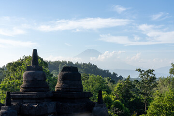 Stupas on top of Borobudur Temple - an important historical Buddhist monument in Magelang, Indonesia. Mount Sumbing visible in background.