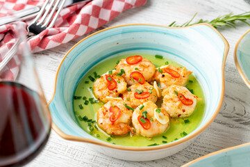 Shrimp appetizer with olive oil on white wooden table
