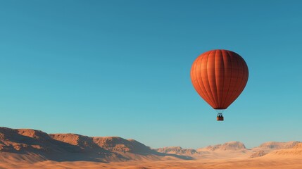 Fototapeta premium A vibrant hot air balloon soars over a picturesque desert landscape under a clear blue sky.