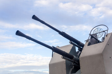 Double-barreled naval automatic cannon against the sky close-up, military background © Evgeny