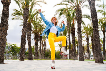 Beautiful red haired young woman with rollerskates having fun outdoors