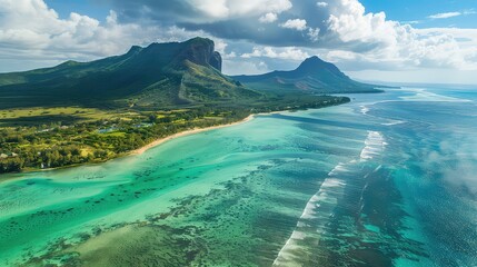 Fototapeta premium An aerial view of a tropical island with mountains, a coastline, and turquoise water with whitecaps.
