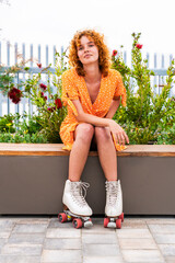 Beautiful red haired young woman with rollerskates having fun outdoors