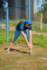 A man is engaged in stretching exercises at an outdoor training facility. He focuses on warming up...