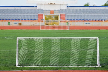 STADIUM - Football field with goal and tablo on blue sky