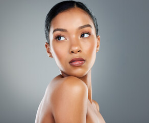 Thinking, makeup or woman with skincare in studio on grey background for facial glow ideas....