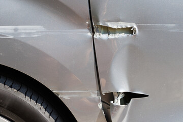 Deep scratches on silver car door and panel