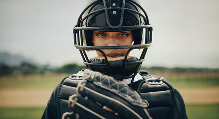 Focused female baseball player in catcher's gear poised to catch the ball on the field