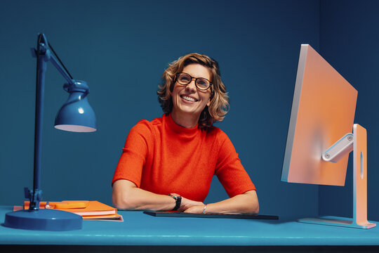 Smiling business woman in vibrant office working on computer