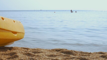 Woman in swimsuit enjoys sunny day at beach, surrounded by calm blue waters. Peaceful scene captures summer relaxation, vacation vibes, and seaside tranquility, perfect for travel themes.