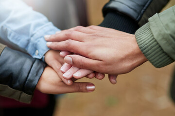 People, group and hands together with friends for unity, motivation or mission in nature. Closeup, team or community piling or touching for collaboration, coordination or solidarity at outdoor park
