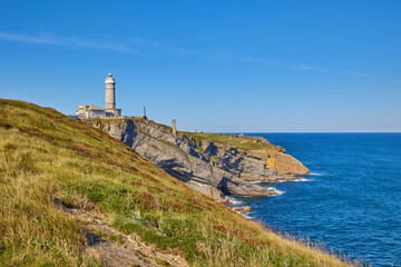 Cape Mayor lighthouse on the rocky coast in Santander, Spain.