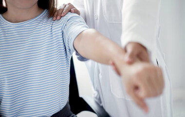 Female physiotherapists provide physical assistance to patients with shoulder injuries massaging their shoulders for muscle recovery in the rehabilitation center. Physiotherapy concepts