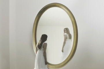 person looks surprised at his image smiling at him in the mirror; identity crisis concept