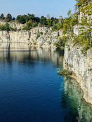 an old quarry with clear water, rocks and wonderful views in the middle of the city