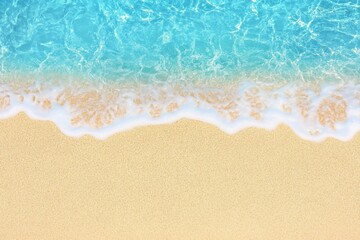 Top-down view of a sandy beach with blue water and waves, web banner design with copy space on the right for text or graphics.