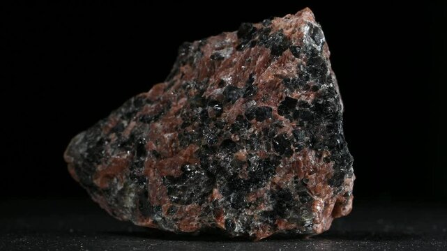 Granodiorite (phaneritic-textured intrusive igneous rock similar to granite, but with more plagioclase feldspar than orthoclase feldspar) rotating slowly against a black background [Norway]