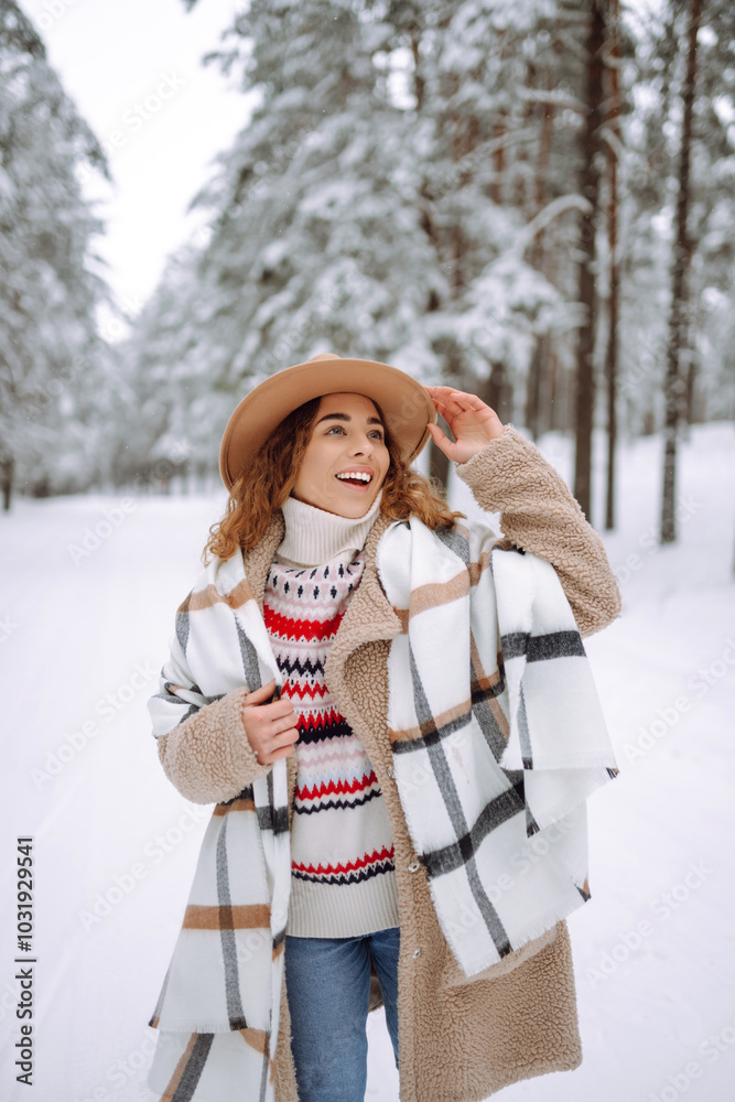 Wall mural happy woman among snowy trees in winter forest, enjoying the first snow in hat and coat. boho style.