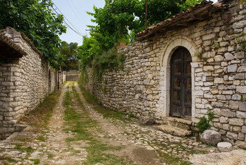 A grassy cobblestoned lane in the historic residential quarter of the castle district, Kalaja, of Berat in southern Albania. Traditional stone walls. UNESCO World Heritage Site listed