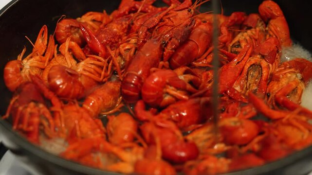 Delicious Crayfish Frying in Pan, Showcasing Traditional Delicacy Preparation During Summer Gathering. Close-up of summer gourmet crawfish. River crayfish are boiling in wok