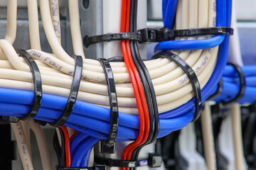 The reverse side of the electrical switchboard. The connected wires are tied with plastic ties.