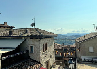 View from above on the roofs of the ancient houses of San Marino, above which the boundless...
