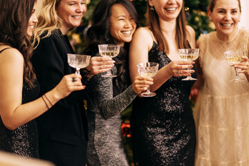 Close-up of female hands with elegant champagne glasses.