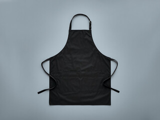 Blank black baker chef apron mockup for professional kitchen staff front view with adjustable ss