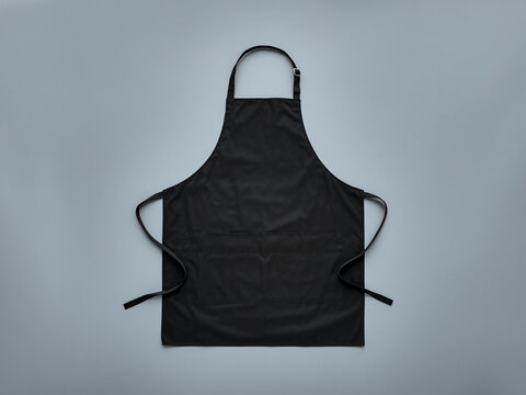 Blank black baker chef apron mockup for professional kitchen staff front view with adjustable ss