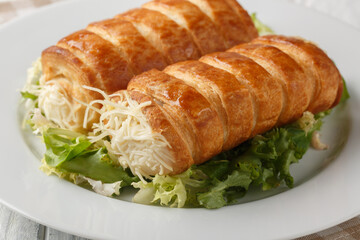 Appetizer Roules au fromage puff pastry tubes stuffed with Gruyere cheese and bechamel sauce close-up in a plate on the table. Horizontal