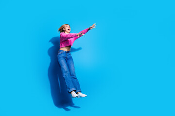 Full size photo of pretty young woman jump fall empty space wear pullover isolated on blue color background