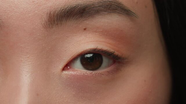 Extreme close up female dark eyes details Asian woman girl korean chinese ethnic healthy japanese lady eyesight human eye opening iris eyeball blink eyelash gaze vision beauty face skincare cosmetics