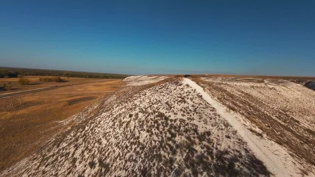 The camera flies low over the chalk mountains, there is no one around and a beautiful view from above.