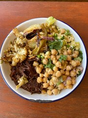 A plate of healthy meal served with slow cook beef cheek, roasted cauliflowers and chickpea salad 