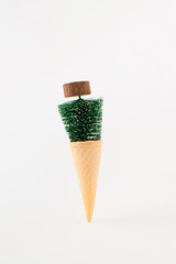 Ice cream cone with Christmas tree on a white background. Minimal Christmas holiday food concept.