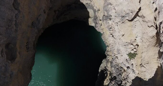 Aerial drone view from drone descending in sea cave on the Atlantic Ocean coastline in Benagil, Algarve, Portugal, Europe. Nature in the Mediterranean. Shot in 5K ProRes 422HQ, exported in ProRes