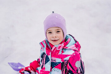 Happy and cheerful child outdoors in winter on the background of snow. Hello winter