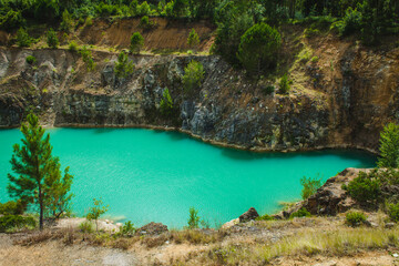 A striking turquoise lake surrounded by rocky cliffs and lush vegetation