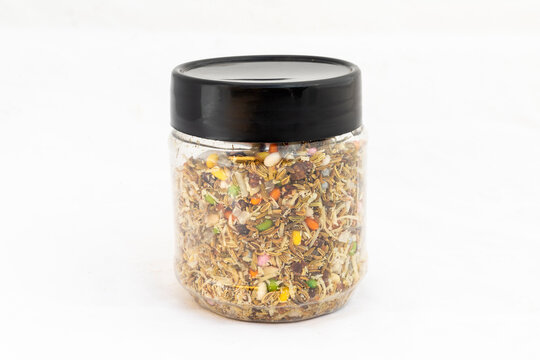 Mix Meva and Pan Masala with mixed dry fruits, fennel, seeds, and nuts scattered in a plastic transparent jar on white isolated background